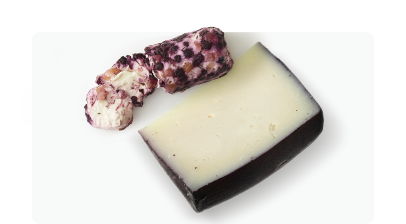 Block and wedge of goat cheese on a white surface