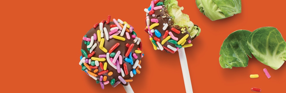 brussels sprouts covered in melted chocolate and rainbow sprinkles that look like cake pops