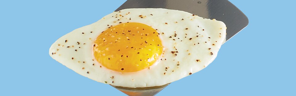 Sunny-side up fried egg on spatula