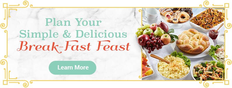 breakfast meal for yom kippur featuring challah, pasta salad, apples and pastries