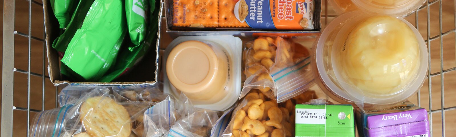 Basket full of snacks like applesauce, juice boxes, fruit cups and crackers Basket full of snacks like applesauce, juice boxes, fruit cups and crackers