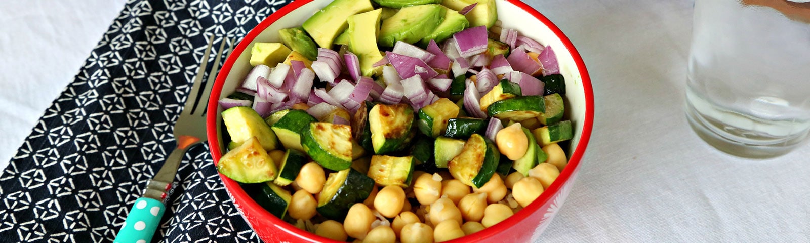 Colorful bowl filled with diced red onion, sliced avocado, sliced roasted zucchini and chickpeas Colorful bowl filled with diced red onion, sliced avocado, sliced roasted zucchini and chickpeas