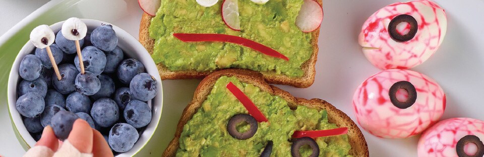 blueberries, avocado toast and hard boiled eggs on a plate