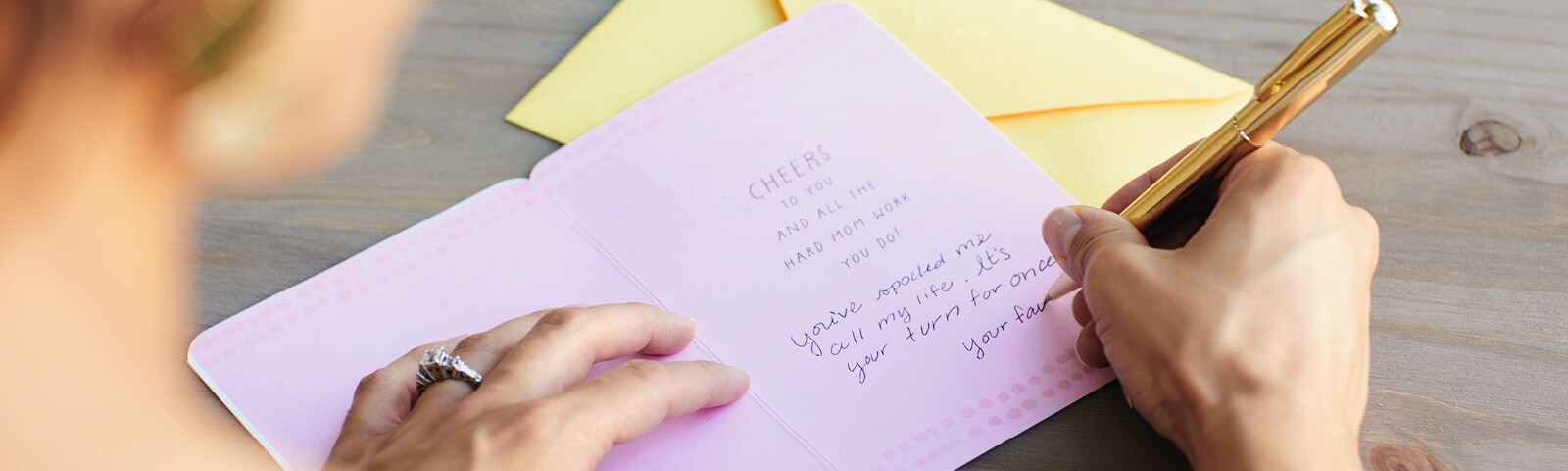 A woman creating a to-do list on pink paper