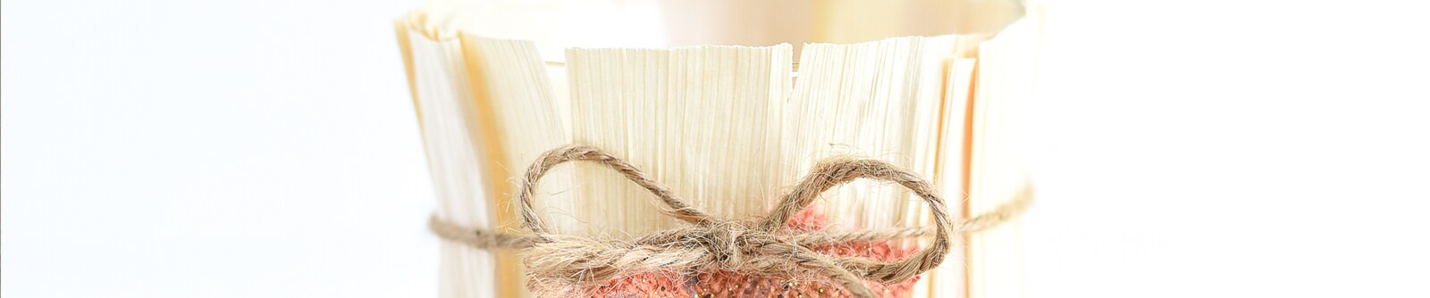 Close up of a DIY cornhusk vase wrapped with a twine ribbon tied into a bow Close up of a DIY cornhusk vase wrapped with a twine ribbon tied into a bow