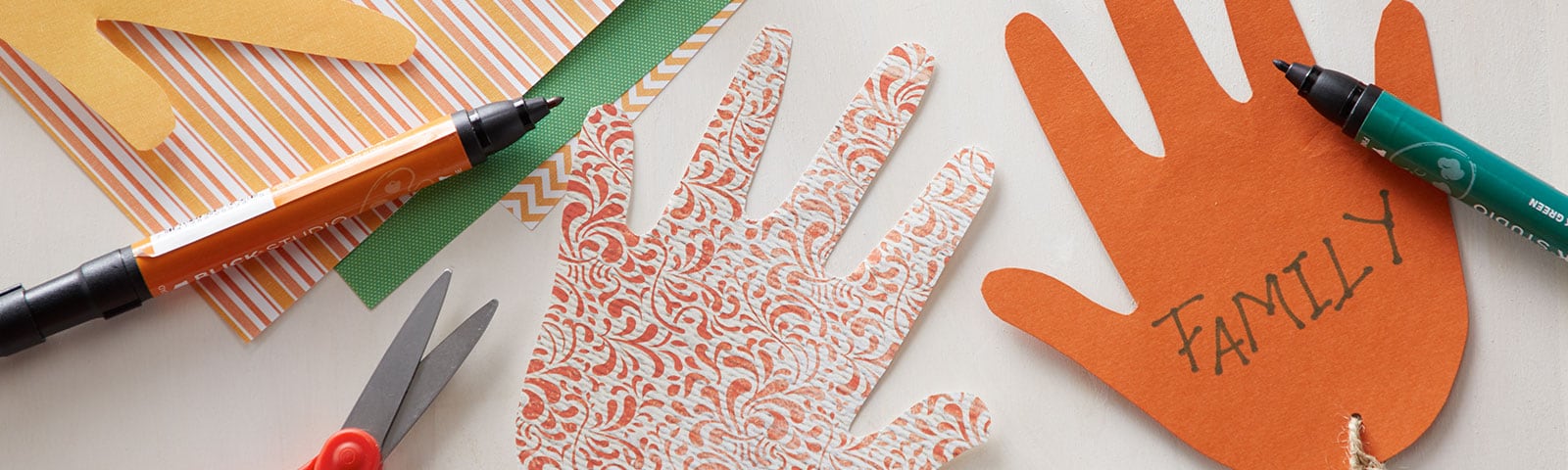 Cut-out paper hands decorated with construction paper and twine Cut-out paper hands decorated with construction paper and twine