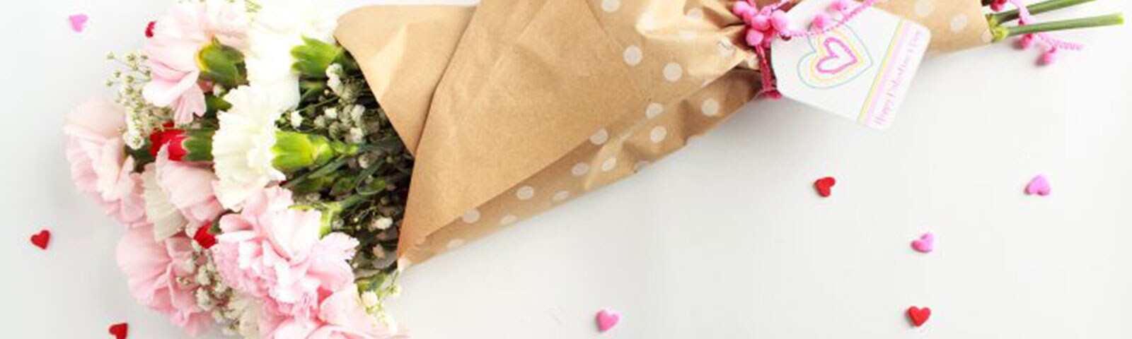 Pink, white, and red carnations flowers wrapped in brown tissue paper as a boutquet Pink, white, and red carnations flowers wrapped in brown tissue paper as a boutquet