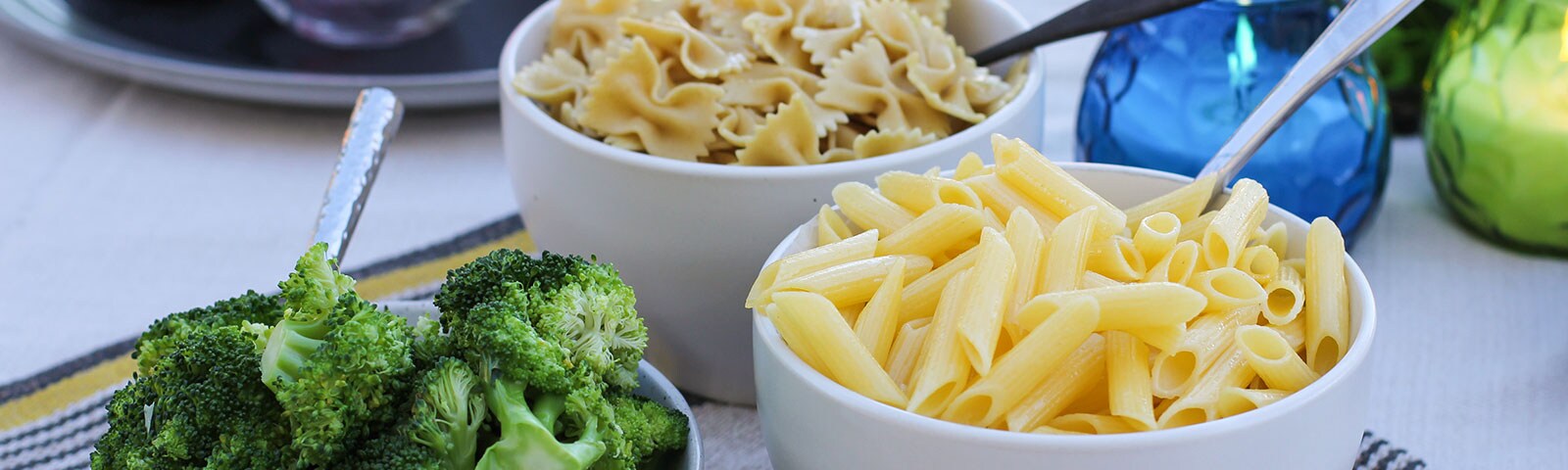 Cooked pasta and broccoli in separate bowls Cooked pasta and broccoli in separate bowls