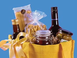 Arrangement of specialty olive oils, premium pasta, olives and a favorite wine in a reusable tote.