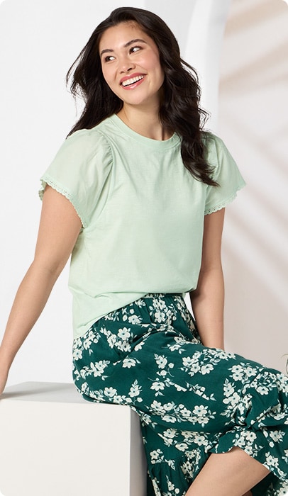 A woman conversating while wearing a featured light green top