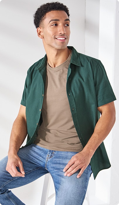 A man wearing a featured outfit with green over shirt and tan under shirt