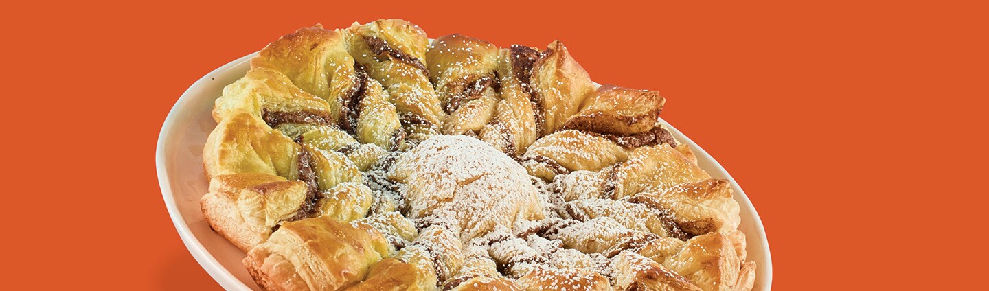 puff pastry snowflake with confectioners’ sugar falling down