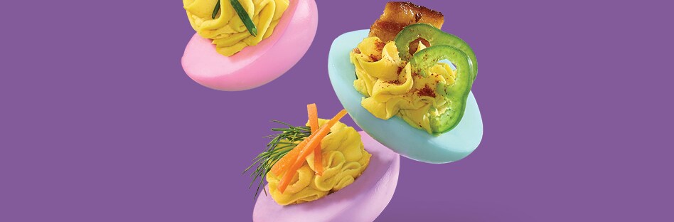 Assorted pastel deviled eggs with a variety of different toppings