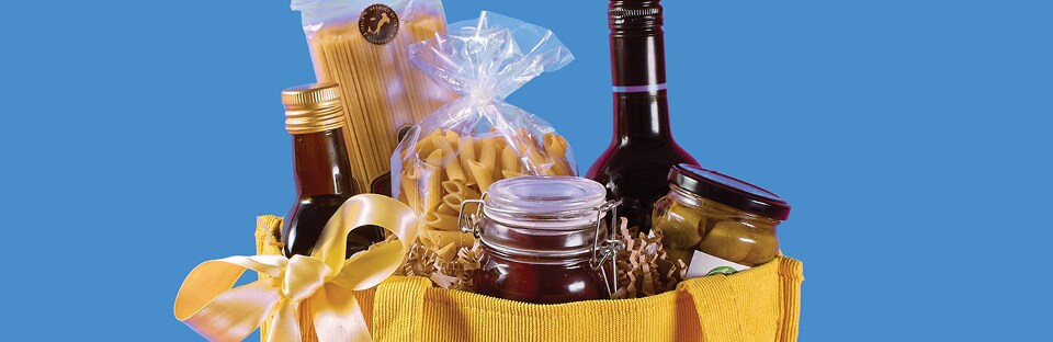 Arrangement of specialty olive oils, premium pasta, olives and a favorite wine in a reusable tote